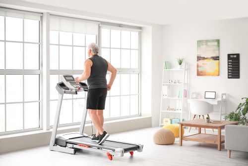 old man using treadmill at home