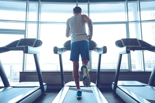 man running on a treadmill in blue shorts