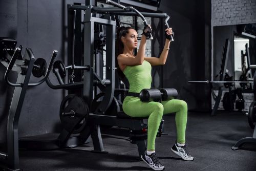 lady at gym using squat machine
