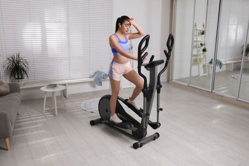 lady sweating on an elliptical at home working out