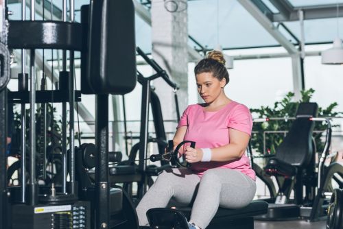 lady at gym trying to use a rowing machine without using legs