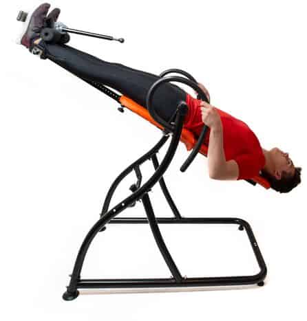 a man in Inverted position while lying on inversion table