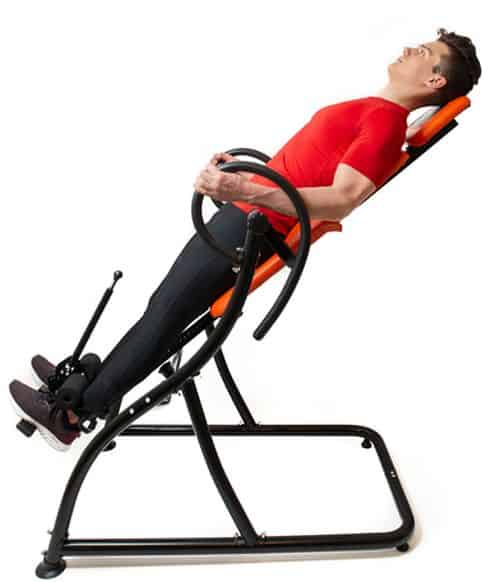 A man on an inversion table inclined in a slight angle