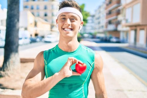 man exercising holding a love heart